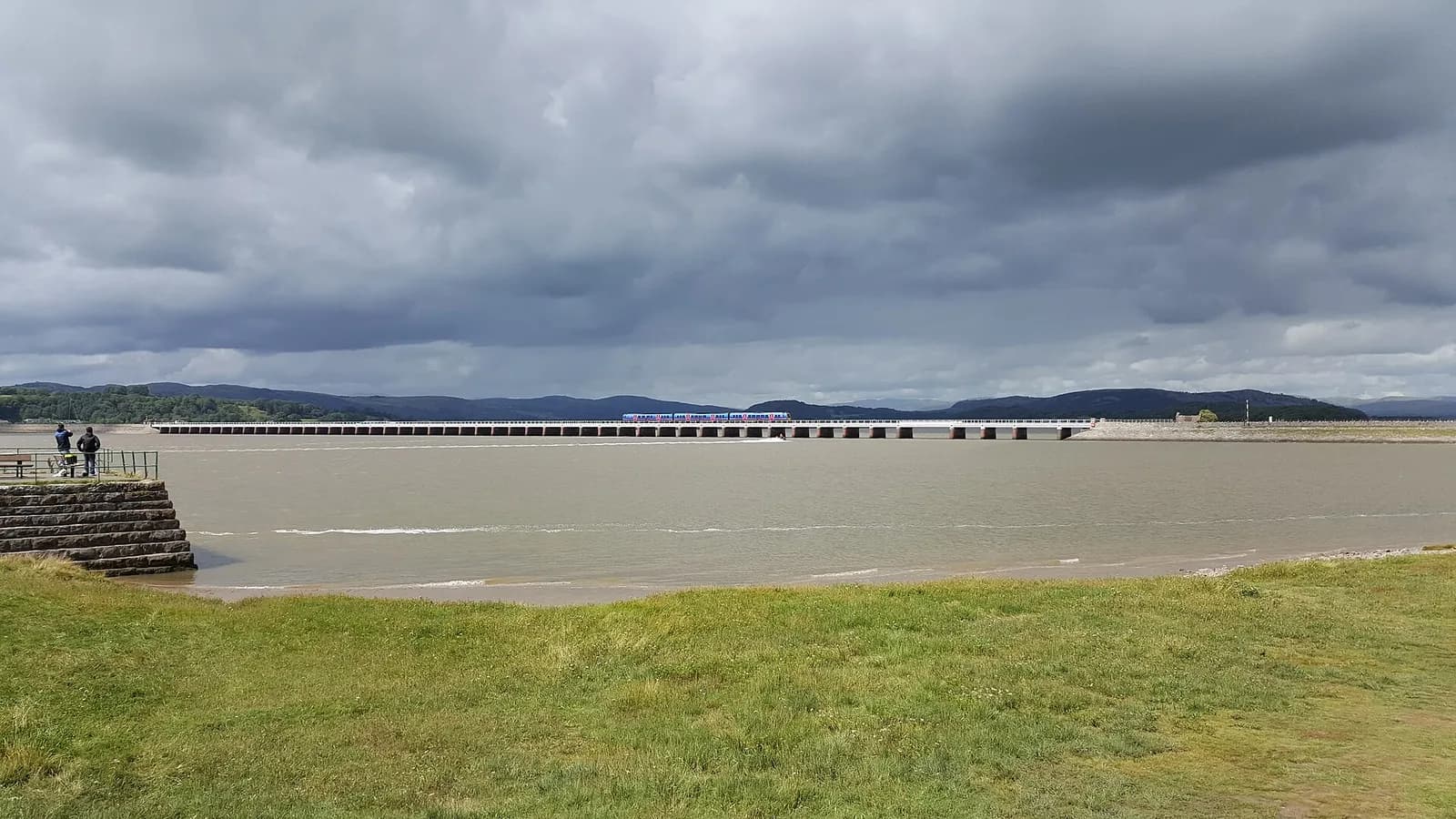 Arnside Viaduct crossing the wide Kent estuary under a stormy sky