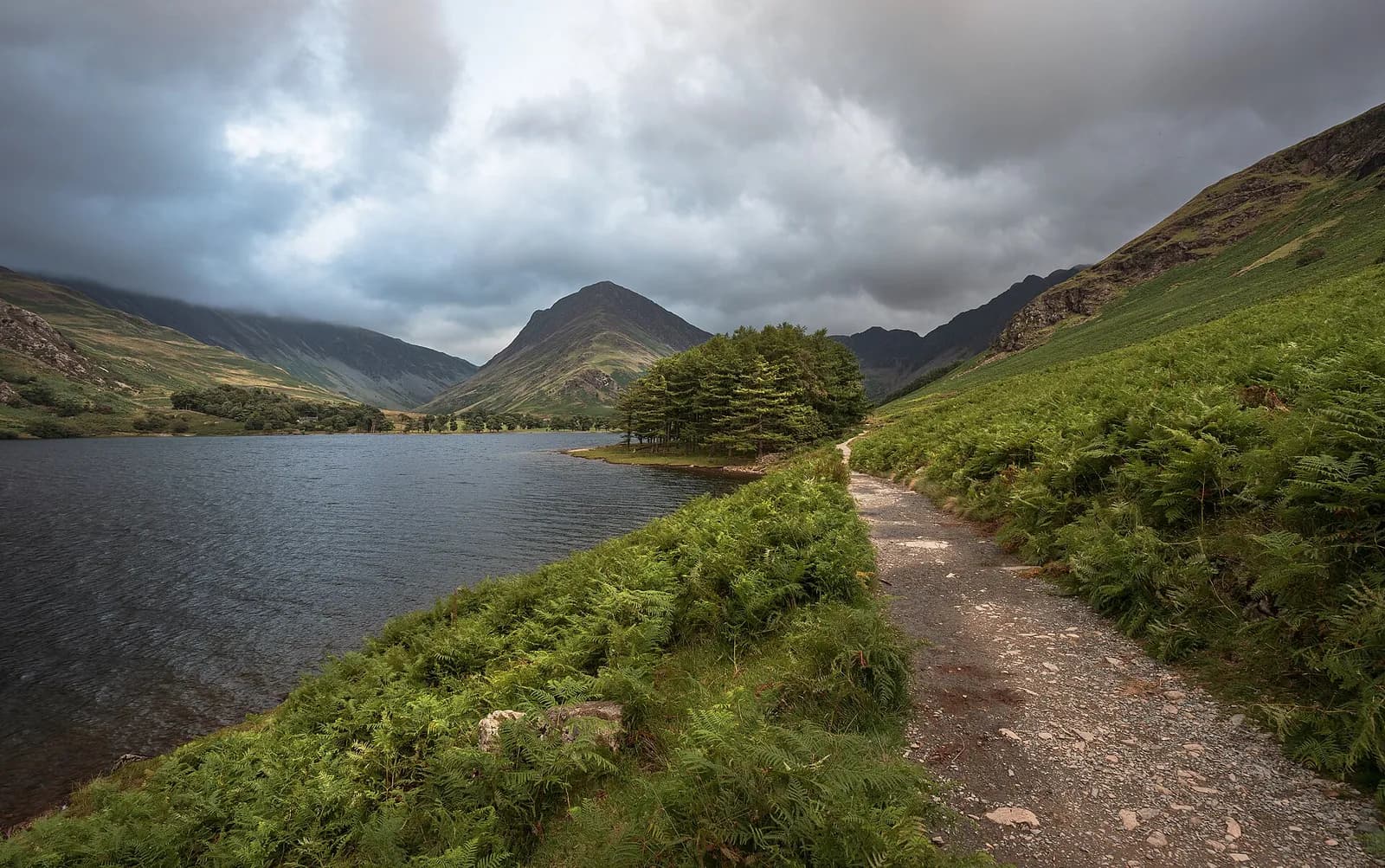 Lakeshore path along Buttermere towards the pines and the pyramid of Fleetwith Pike