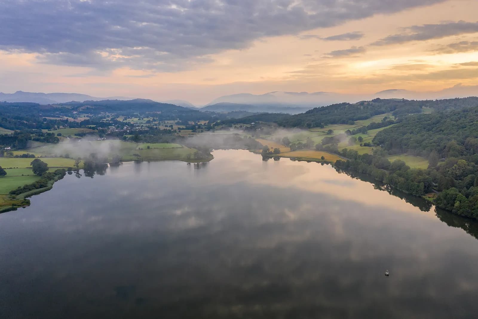 Esthwaite Water at dawn with mist over the fields and the fells on the horizon