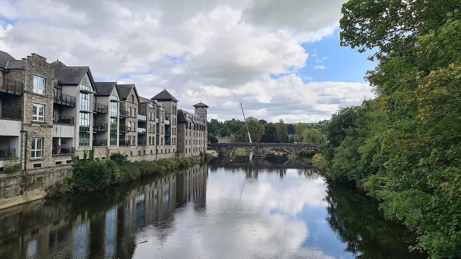The River Kent flowing through Kendal past riverside buildings towards Miller Bridge