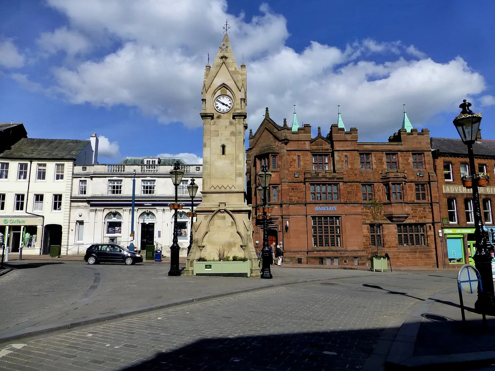 The Musgrave Monument clock tower in Penrith Market Square with red sandstone buildings