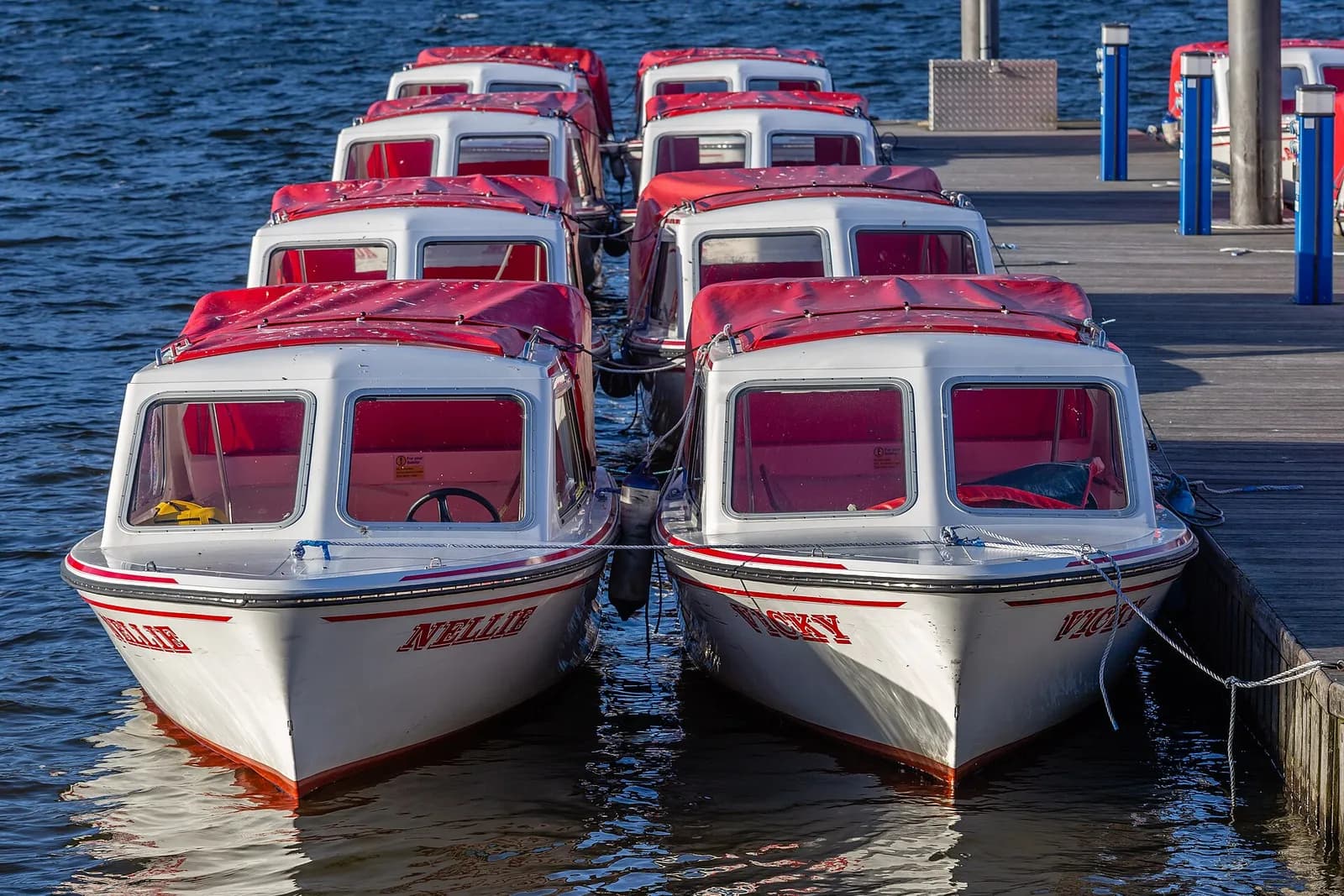 Red and white motor launches moored at the jetties in Bowness Bay