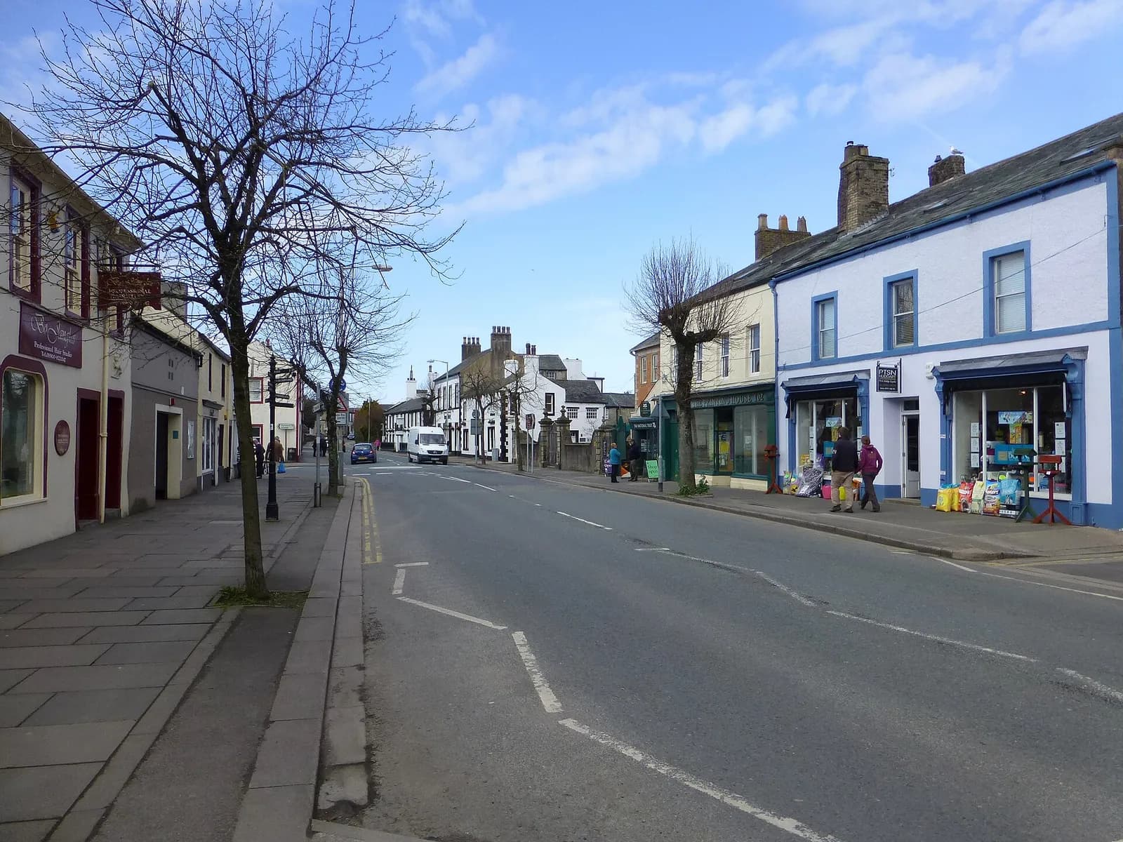 Cockermouth's broad Main Street lined with painted Georgian shopfronts and trees