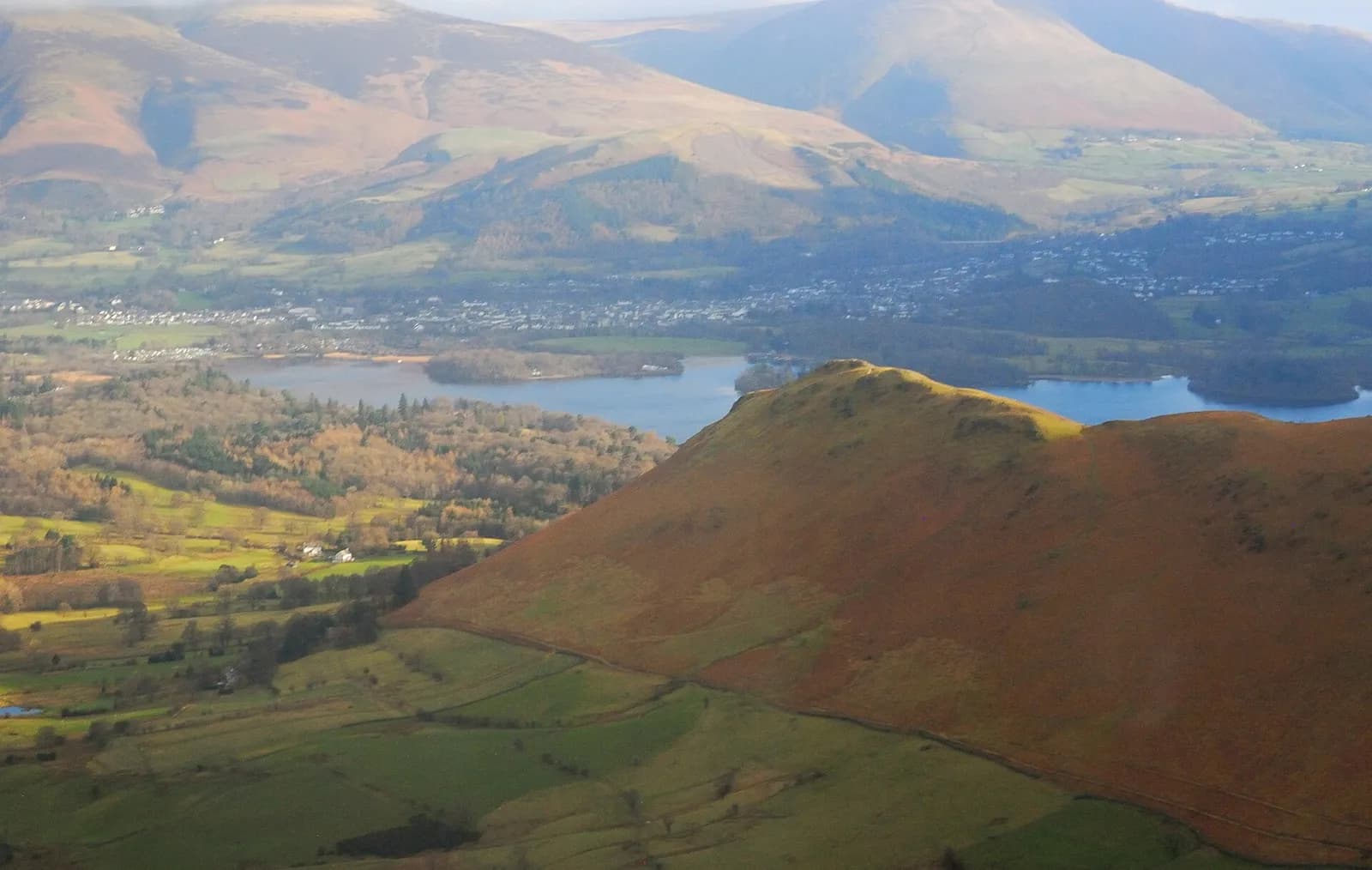 Aerial view over Catbells to Derwentwater, Keswick and Skiddaw in autumn colour