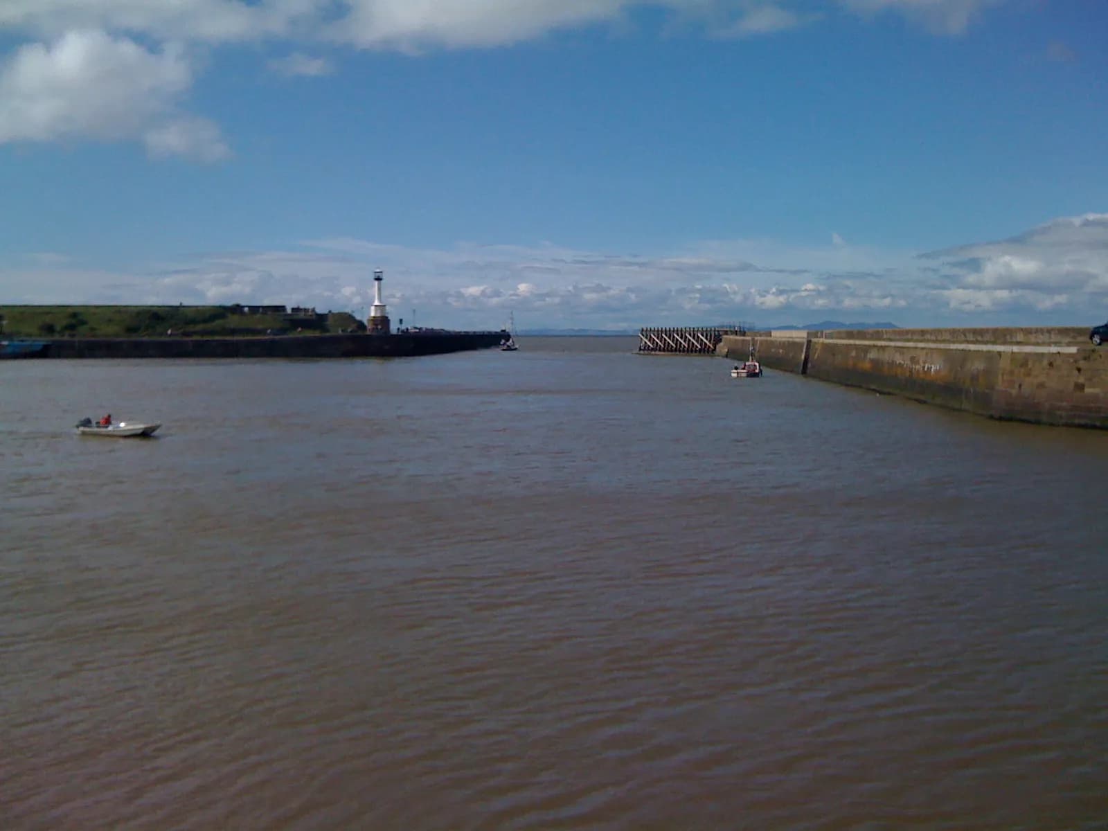 The mouth of Maryport harbour with its pier lighthouse and the Solway Firth