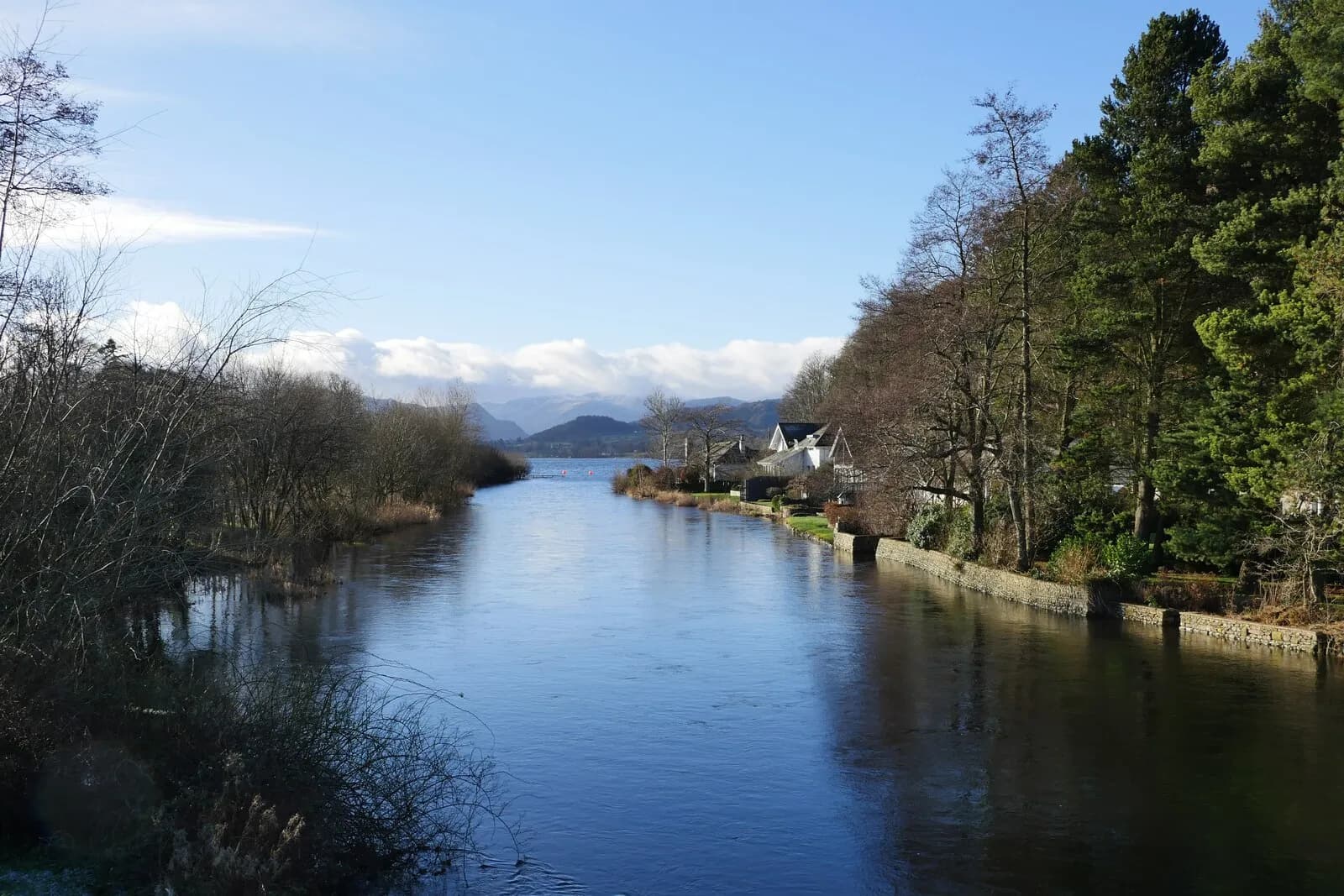 The River Eamont at Pooley Bridge flowing out from Ullswater between wooded banks