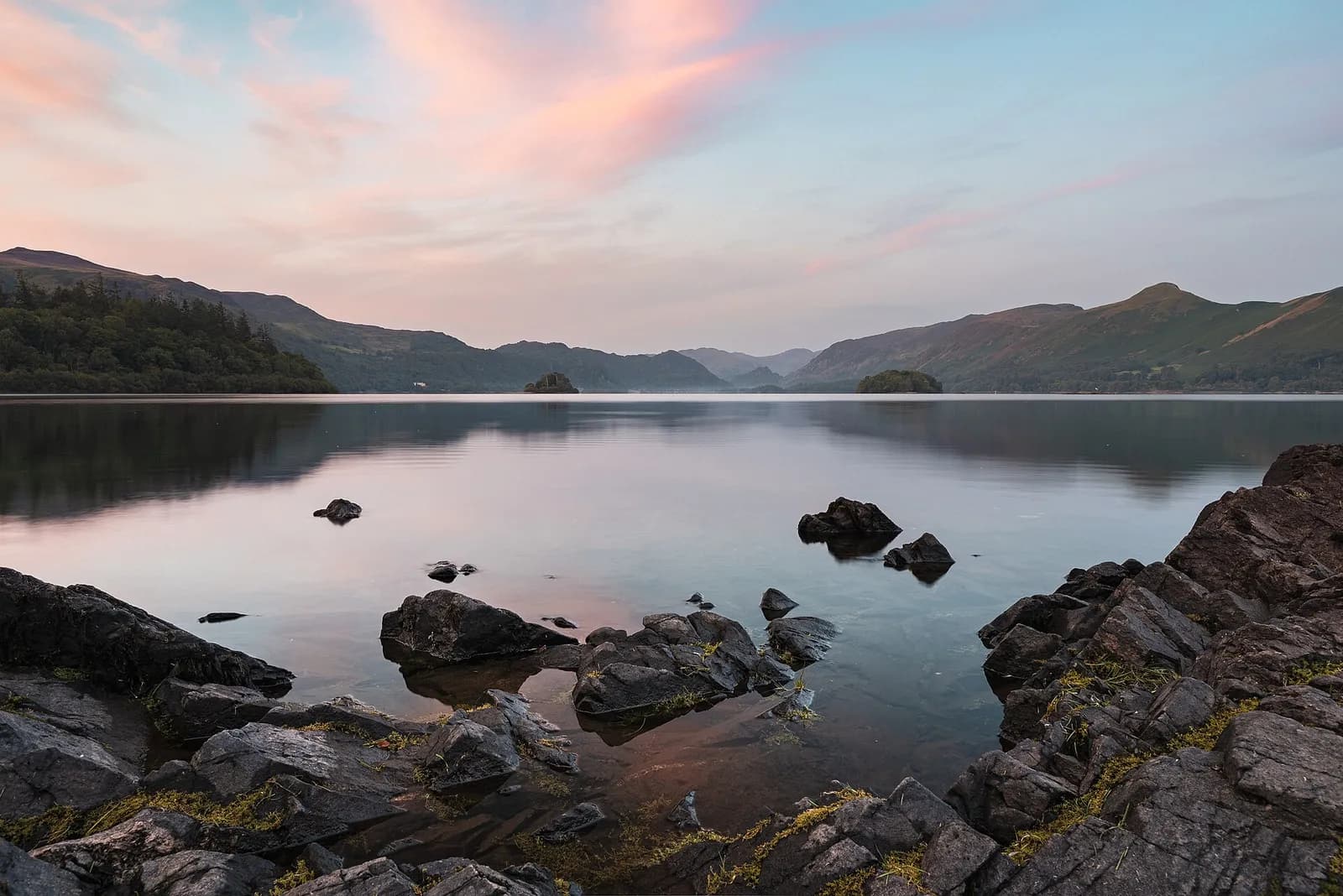 Rocks at Friar's Crag on Derwentwater under a pink evening sky